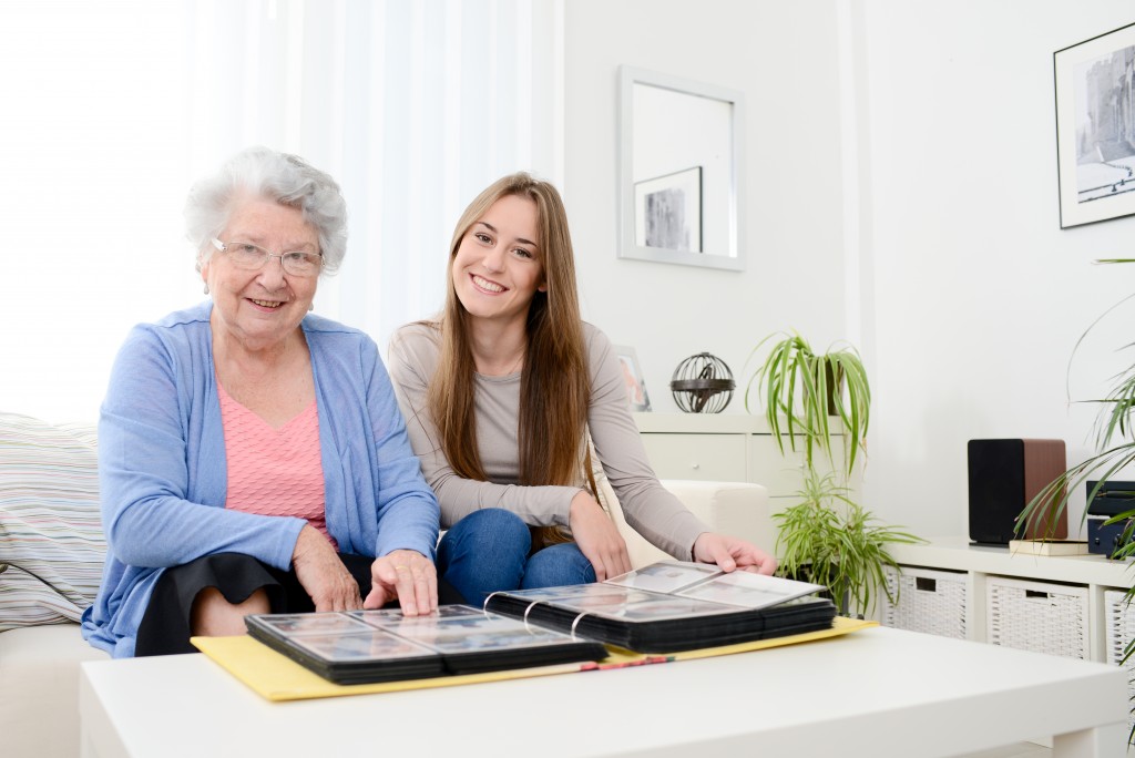 Elderly woman sitting beside her granddaughter