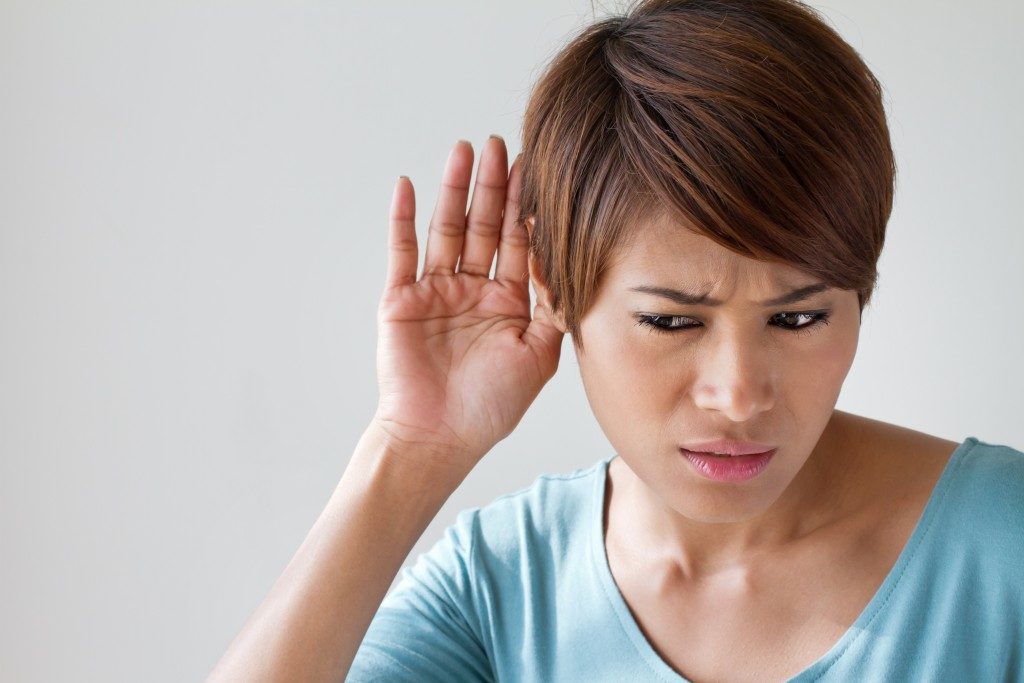 a woman suffers from hearing impairment