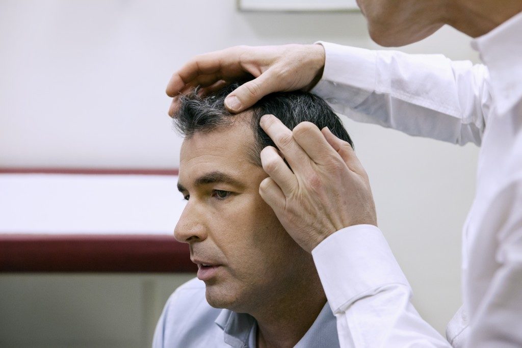man having scalp checked