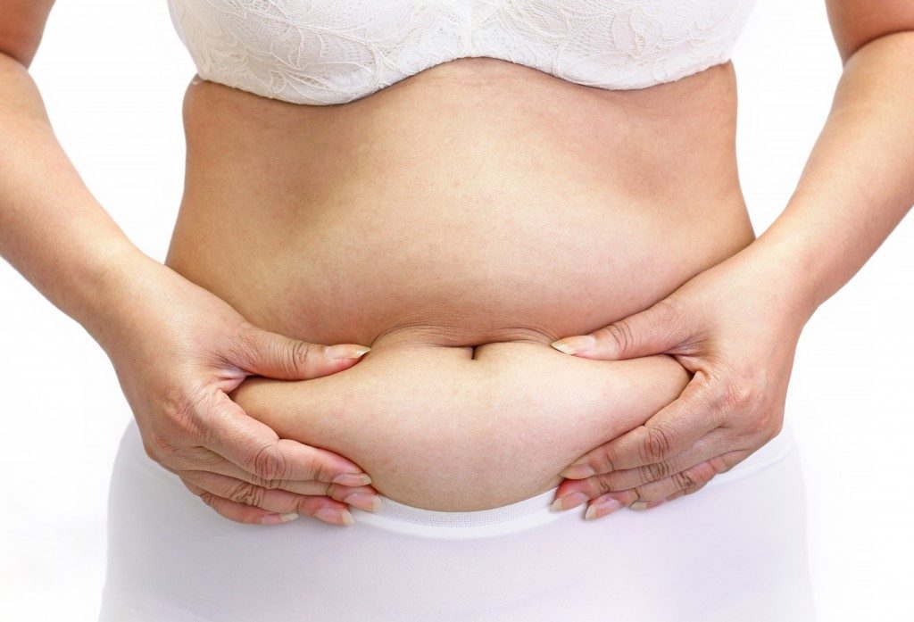 Woman measuring her belly