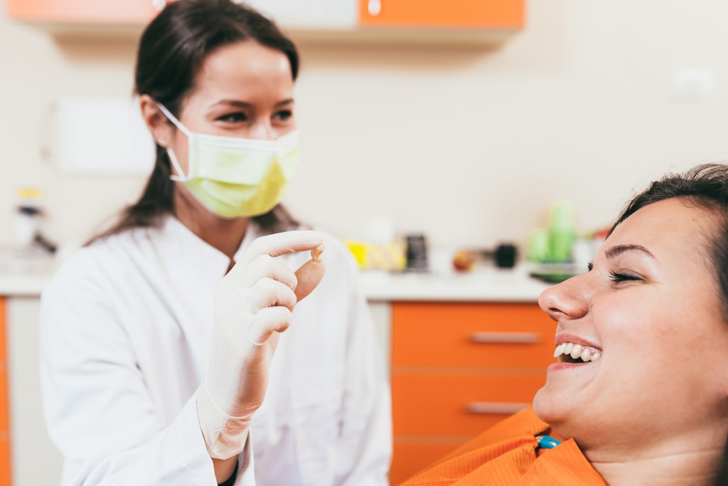 Dentist showing extracted tooth