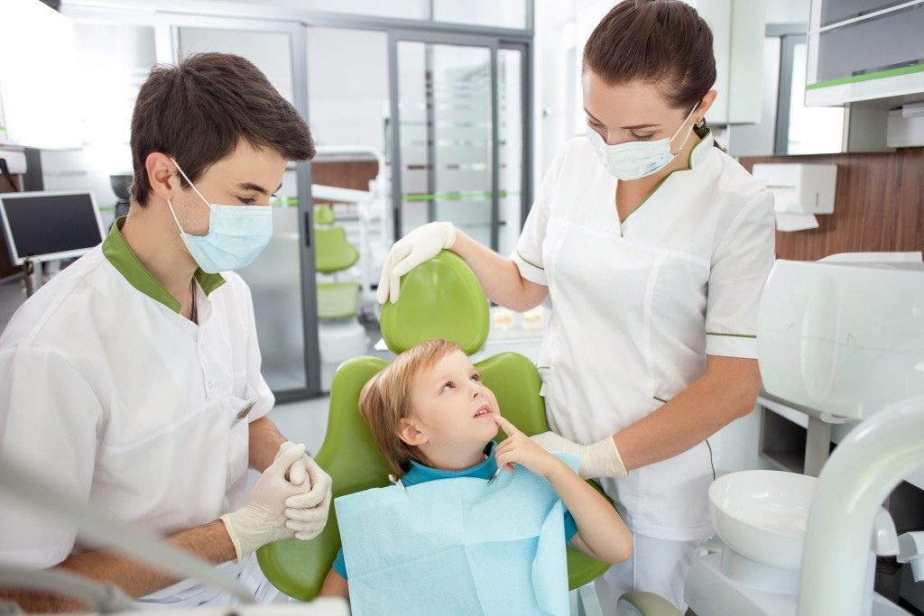 Child on a dental chair with dentists