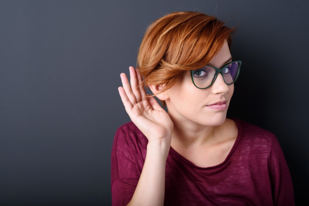 woman cupping her hand behind her ear