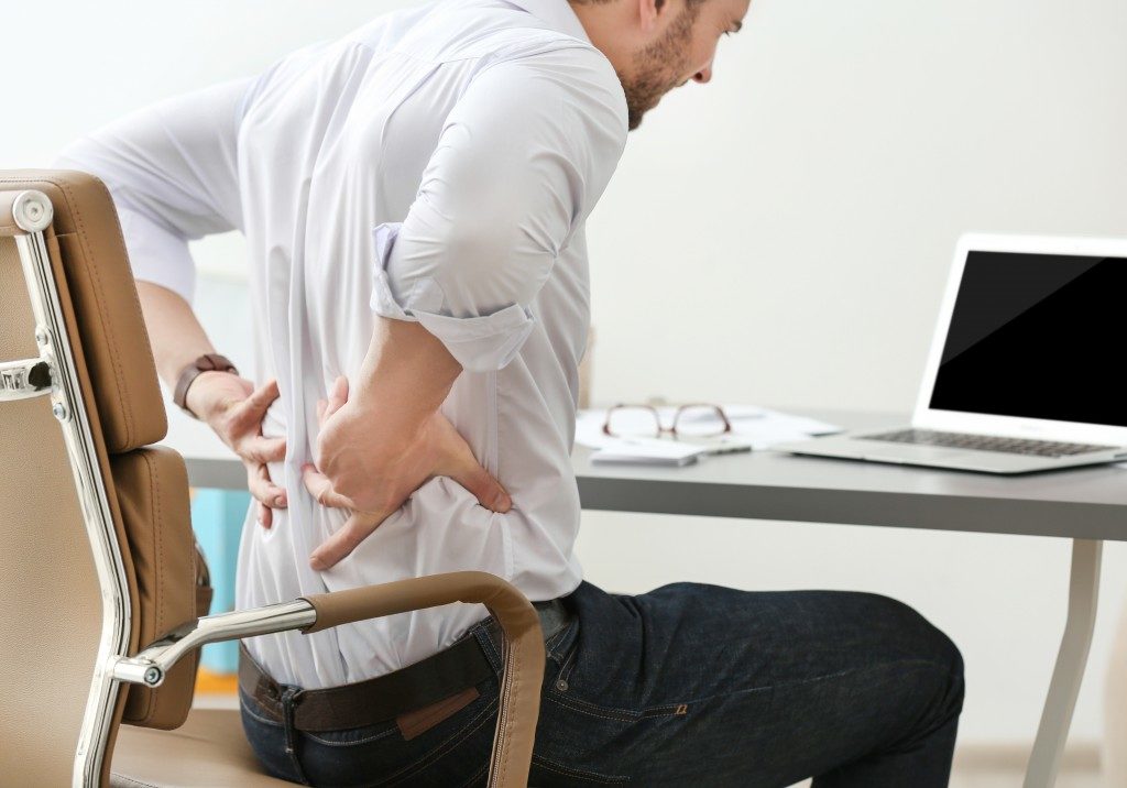 Man with backpain while sitting in his desk
