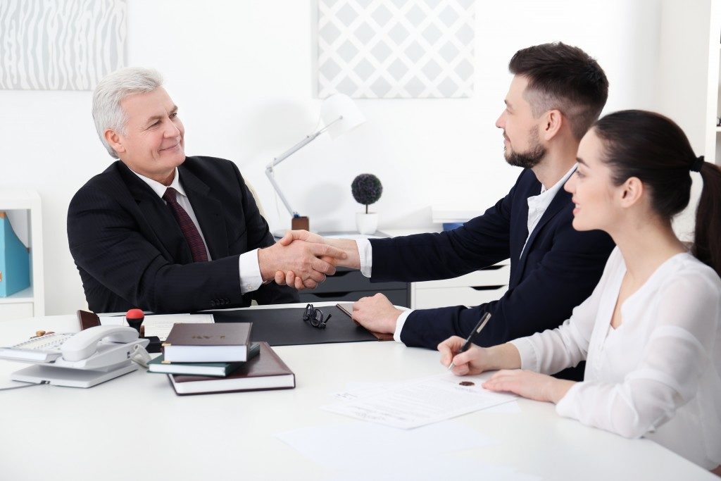 insurance agent shaking hands with couple