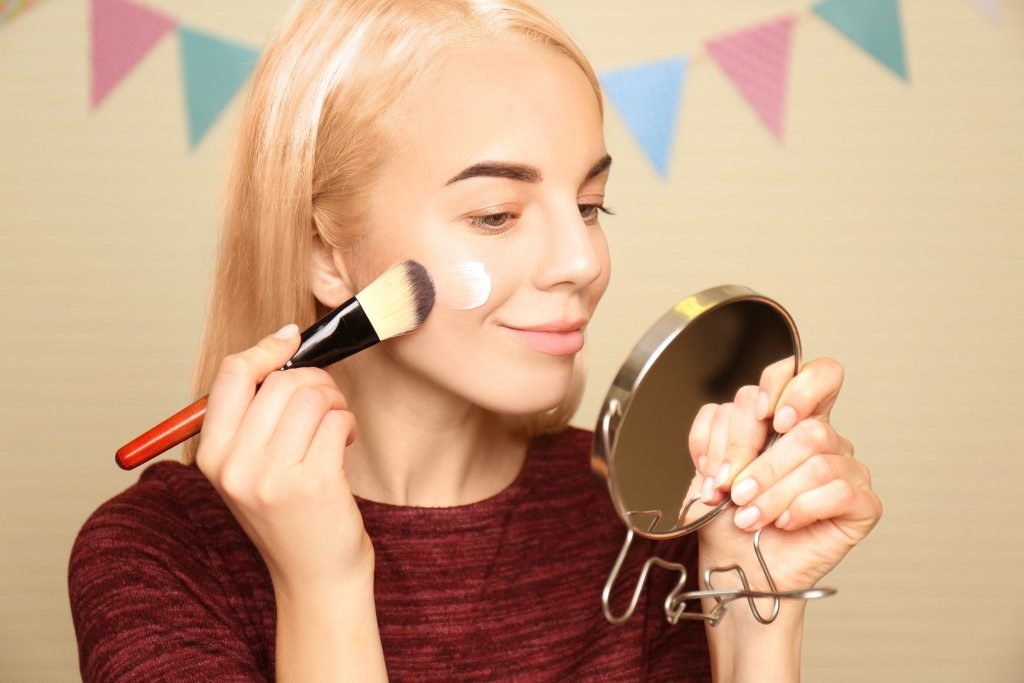 Woman using a makeup brush