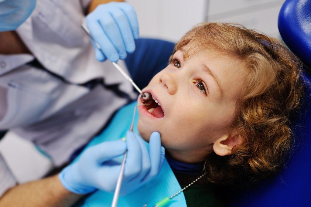 kid having his teeth checked at the dental office