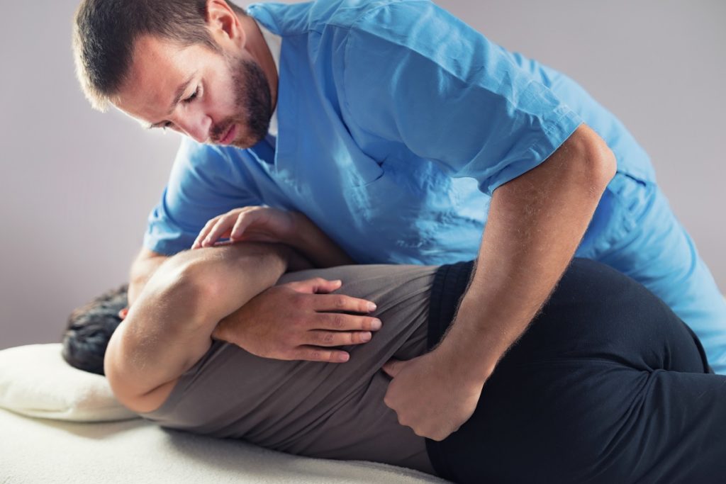 male chiropractor massaging a patient