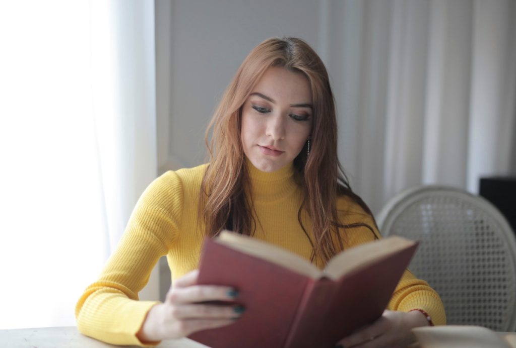 woman in yellow reading book