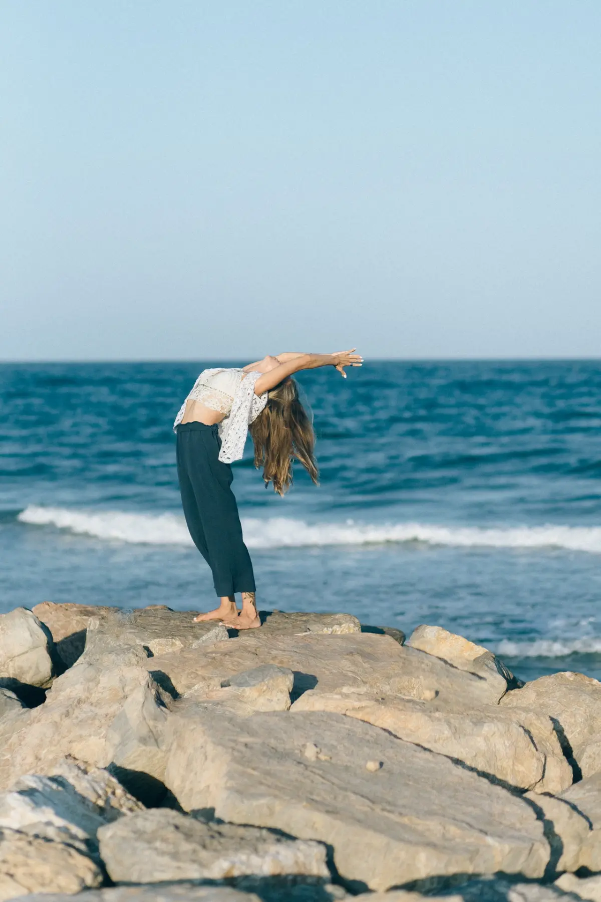 Woman Doing Yoga on Rocky Shore