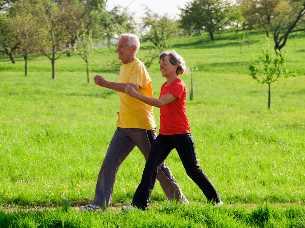 A senior couple brisk walking at a field