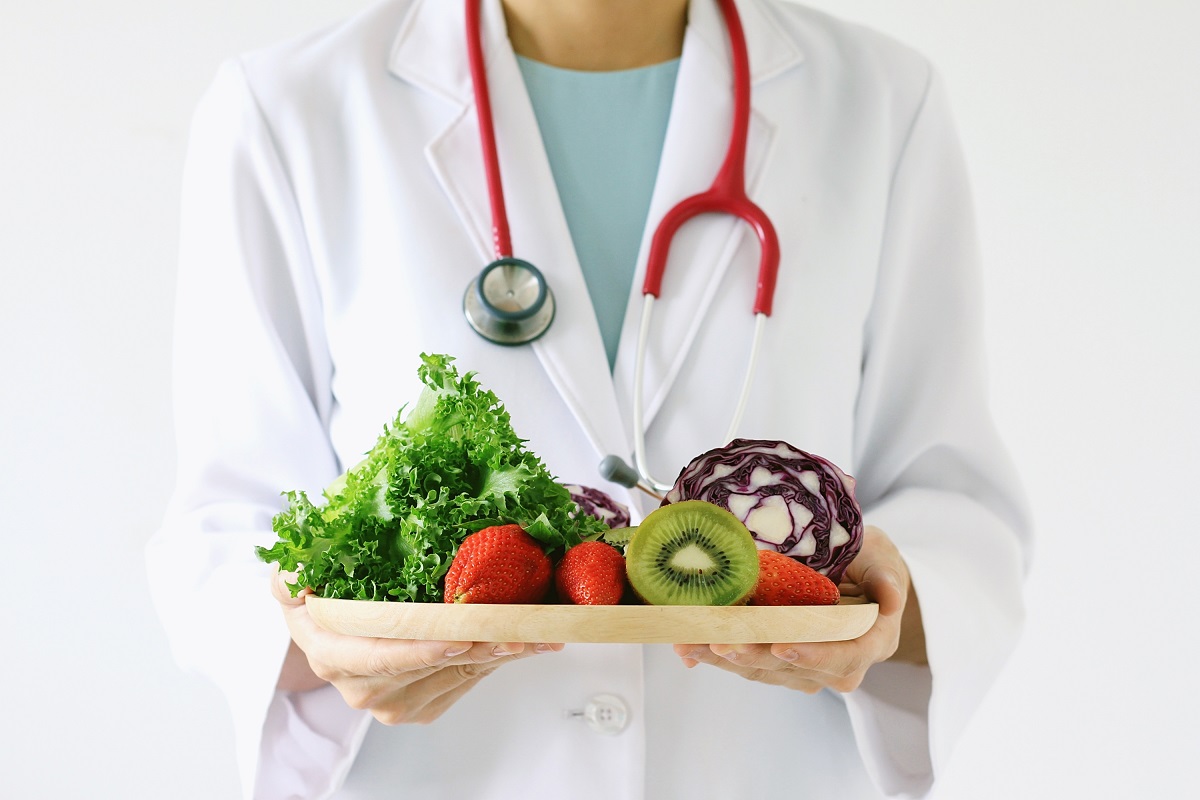 doctor holding big plate of fruits and vegetables