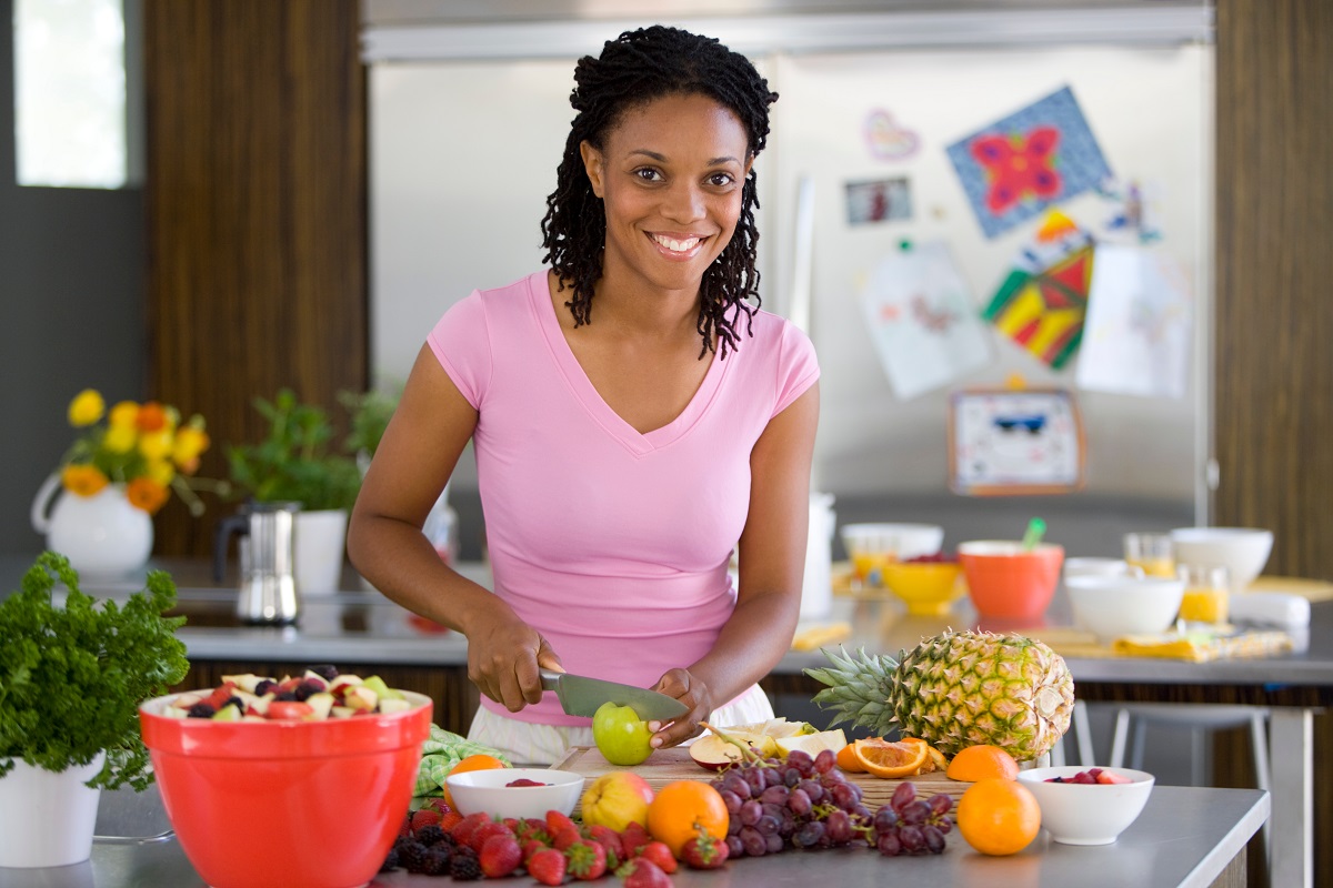 woman making fruit salad in kitchen